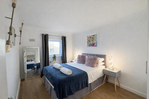 a bedroom with a large bed with a blue blanket at Mango Tree Apartment - Near Leisure Park & Station in Cambridge
