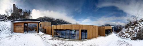 a house in the snow with a mountain in the background at Refugio Laudegg in Ladis