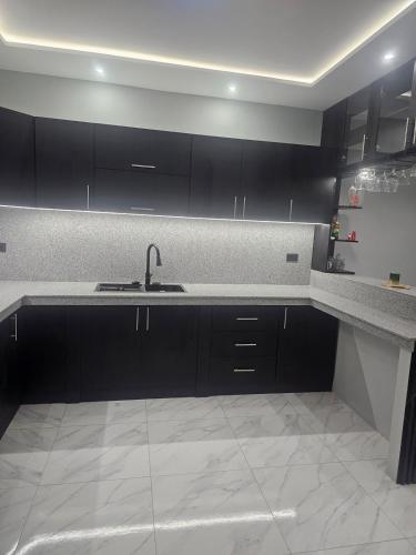 a kitchen with black cabinets and a sink at Newly Opened Mini Suite in Manta