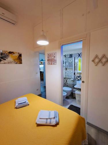 a room with a yellow table with towels on it at La Corte di Noto in Noto