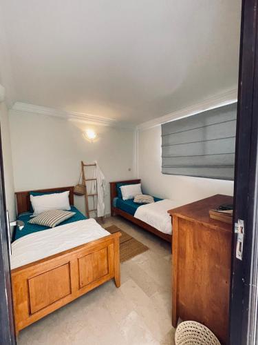 a bedroom with two beds and a night stand at Azul Blue House in Sidi Bouzid