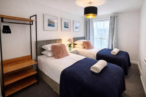 a bedroom with two beds and a window at GreenGage Tree Stylish 2 Bedroom with Balcony & Parking in Cambridge