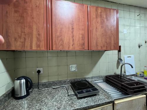 a kitchen with wooden cabinets and a stove top oven at United Holiday Homes in Dubai