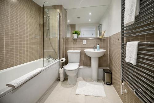 a bathroom with a sink and a toilet and a bath tub at GreenGage Tree Stylish 2 Bedroom with Balcony & Parking in Cambridge
