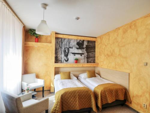 a bedroom with a bed and a chair at U Admirala in Kladno
