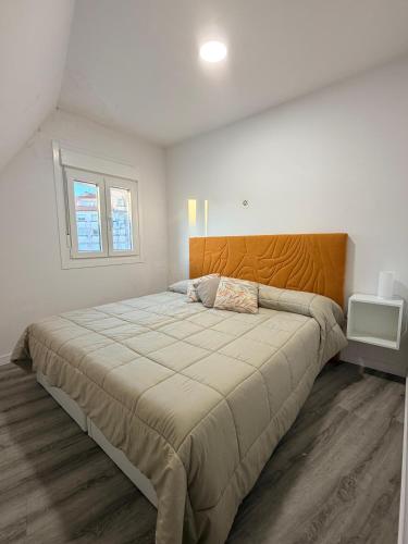 a bedroom with a large bed and a window at Central Suites Silgar Sanxenxo in Sanxenxo