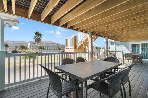 a patio with a table and chairs on a deck at Boardwalk Unit A4 in Pensacola Beach