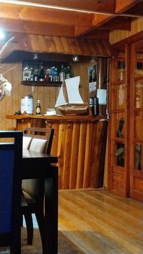 a bar in a room with a table and a piano at Casa Halcon de Lagunitas in Puerto Montt