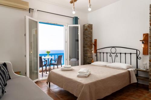 a bedroom with a bed with a view of the ocean at Anemos Sea View in Batsi