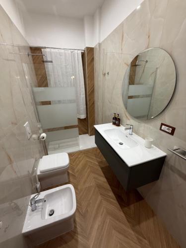a bathroom with a sink and a toilet and a mirror at Le casette apartaments in Torre Annunziata