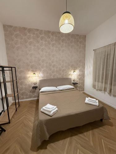 a bedroom with a bed with two towels on it at Le casette apartaments in Torre Annunziata