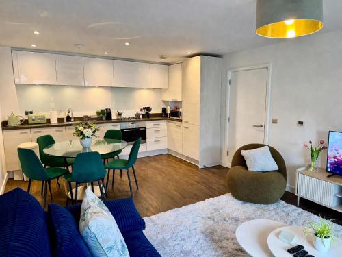 a kitchen and a living room with a table and chairs at Avacado Tree Apartment - near Cambridge Station in Cambridge