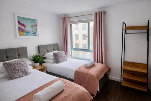 a bedroom with two beds and a window at Avacado Tree Apartment - near Cambridge Station in Cambridge