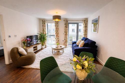 a living room with a blue couch and chairs at Avacado Tree Apartment - near Cambridge Station in Cambridge