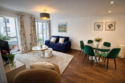 a living room with a blue couch and green chairs at Avacado Tree Apartment - near Cambridge Station in Cambridge