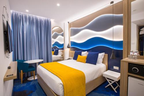 a hotel room with a bed with a painting on the wall at Hotel Carlton in Tunis
