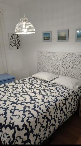 a bedroom with a bed with a black and white comforter at Casa de Praia in Vila do Conde