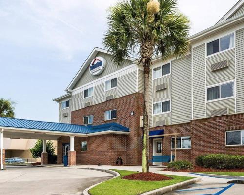 a hotel with a palm tree in front of a building at Suburban Studios Avondale in Avondale