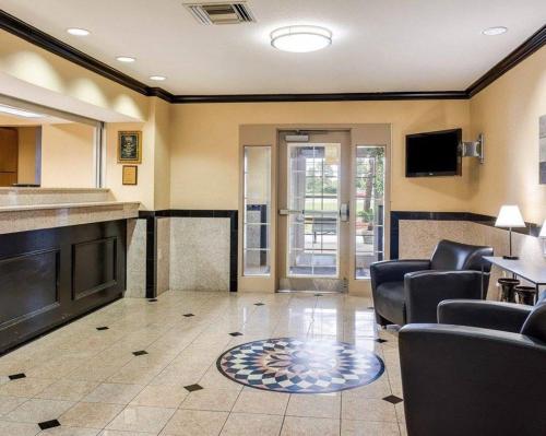 a living room with a couch and chairs and a tv at Suburban Studios Avondale in Avondale