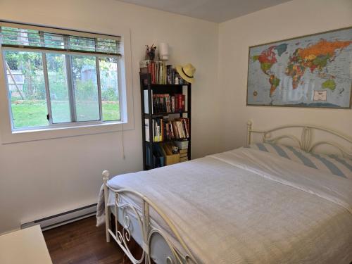a bedroom with a bed and a book shelf with books at Hammond bay planta house in Nanaimo