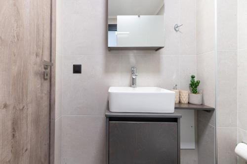 a bathroom with a white sink and a mirror at AORA Asites Mountain View in Kato Asites
