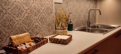 a kitchen counter with baskets and a sink at Niki`s Luxury Apartment in Makry Gialos