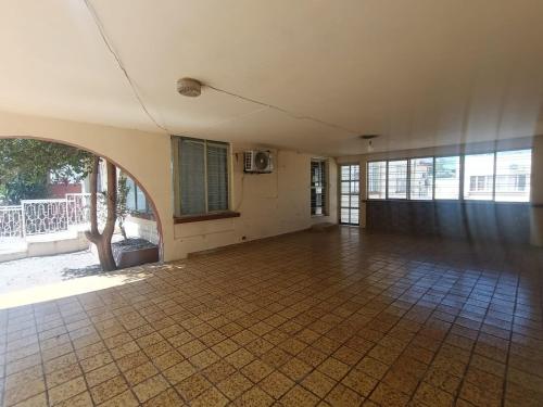 an empty room with a tiled floor and windows at Casa Emilio Carranza, Linares in Linares
