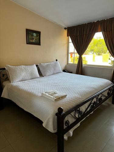 a bed with two towels on it in a bedroom at Hostal Casa Grande in Quito
