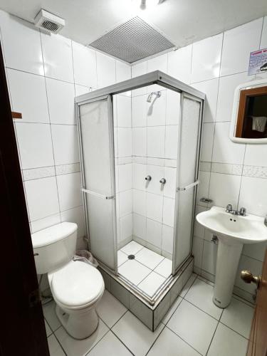 a bathroom with a shower and a toilet and a sink at Hostal Casa Grande in Quito