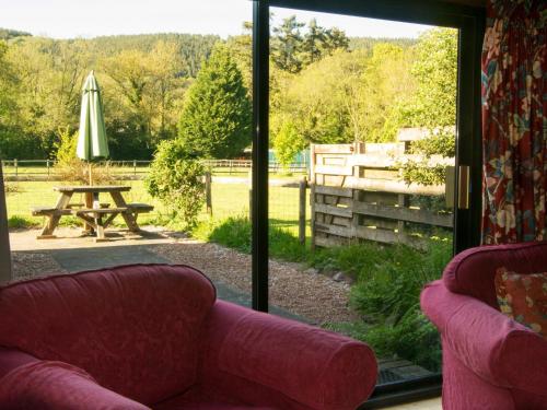 a living room with a sliding glass door and a picnic table at Stables- Ukc4912 in Timberscombe