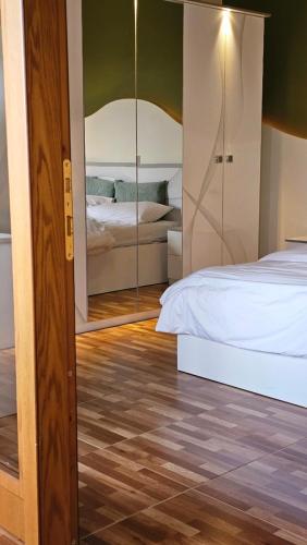 a bedroom with a bed and a mirror at Lemon Garden Apartment-Hot Tub Jacuzzi in Gjirokastër