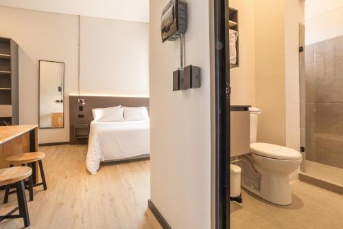 a small bathroom with a bed and a toilet at Break Estudios Manizales in Manizales