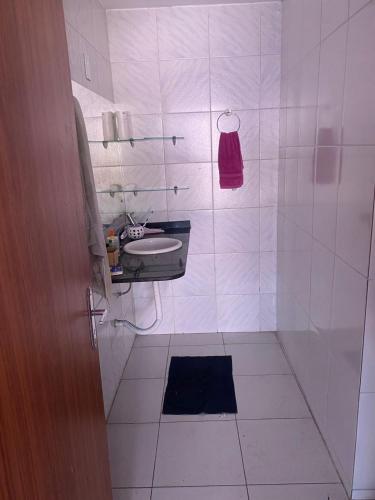 a white bathroom with a sink and a shower at Hostel Namastê in Maceió