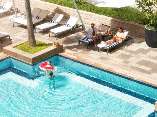 a group of people sitting in a swimming pool at Swissôtel Al Ghurair Dubai in Dubai