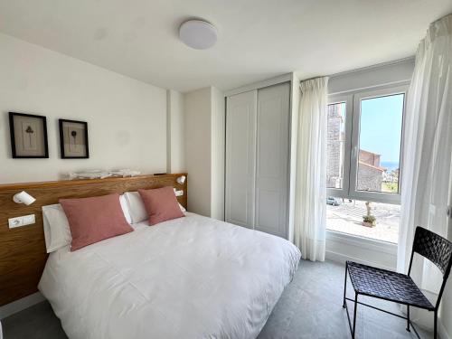 a bedroom with a white bed and a window at Apartamento Calas in Noja
