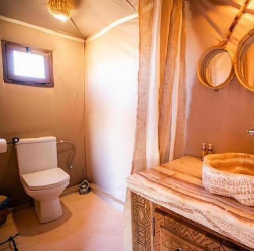 a bathroom with a toilet and a sink at Merzouga Retreat Camp in Merzouga
