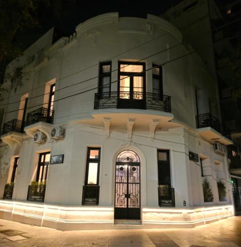 a large white building with a door at night at Hotel Boutique Ubuntu in Buenos Aires