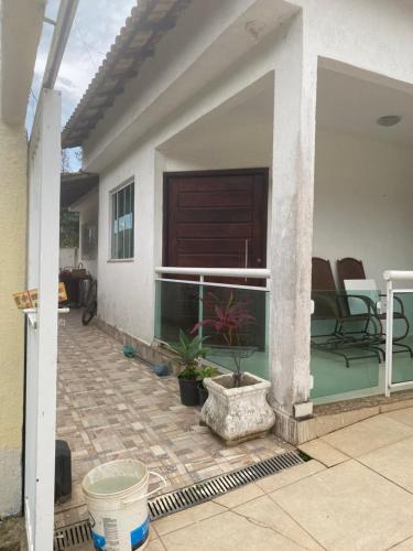 a house with a porch with a patio at Casa dá Jo in Rio das Ostras