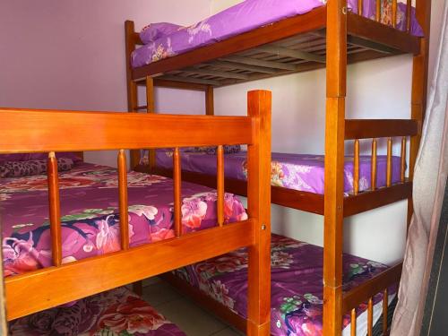 two bunk beds in a room with purple sheets at Hostel Namastê in Maceió