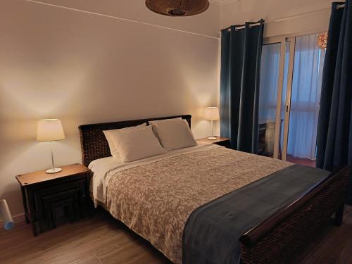 a bedroom with a bed with two lamps and a window at Casa da Baleia Ericeira in Ericeira