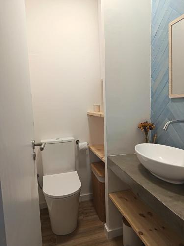 a bathroom with a white toilet and a sink at Casa da Baleia Ericeira in Ericeira