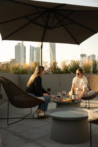 two people sitting at a table under an umbrella at Casa Cibeles by Lumina in Mexico City