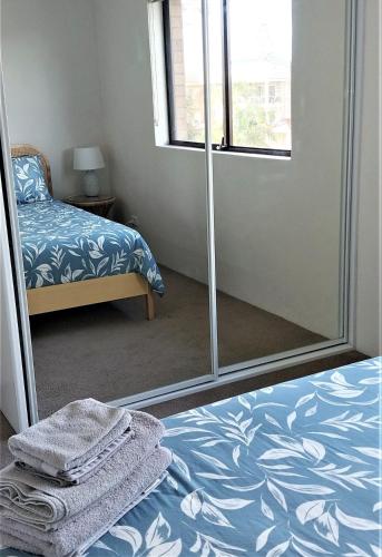 a bedroom with a mirror and a bed and a window at Shoal Bay Water Views, 1 night stays available in Nelson Bay
