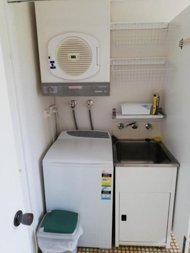 a small kitchen with a sink and a refrigerator at Shoal Bay Water Views, 1 night stays available in Nelson Bay