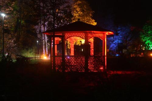a gazebo lit up with red lights at night at Ferienwohnungen Schenk Schmitz in Bad Bertrich