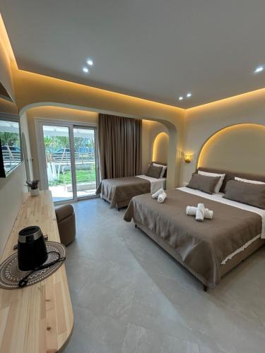 duża sypialnia z dwoma łóżkami i telewizorem w obiekcie Ionian View B&B w mieście Himara