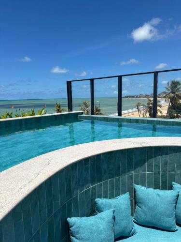 a swimming pool with a view of the ocean at Garden Haus - Flat beira mar in João Pessoa