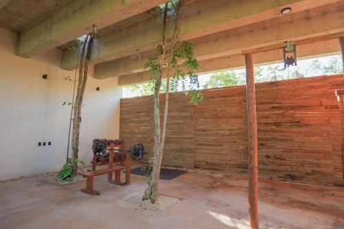 a room with a wooden wall and a swing at Limas in Tulum