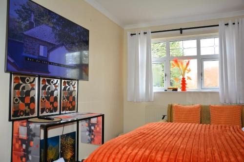 a bedroom with a bed and a tv on the wall at A Room in 4 Bedrooms Home at 34 Forge in Tettenhall