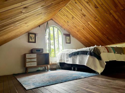 a attic room with a bed and a window at Tu Refugio en el Campo in San Francisco